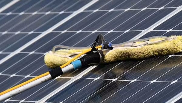Technicien nettoyant des panneaux solaires